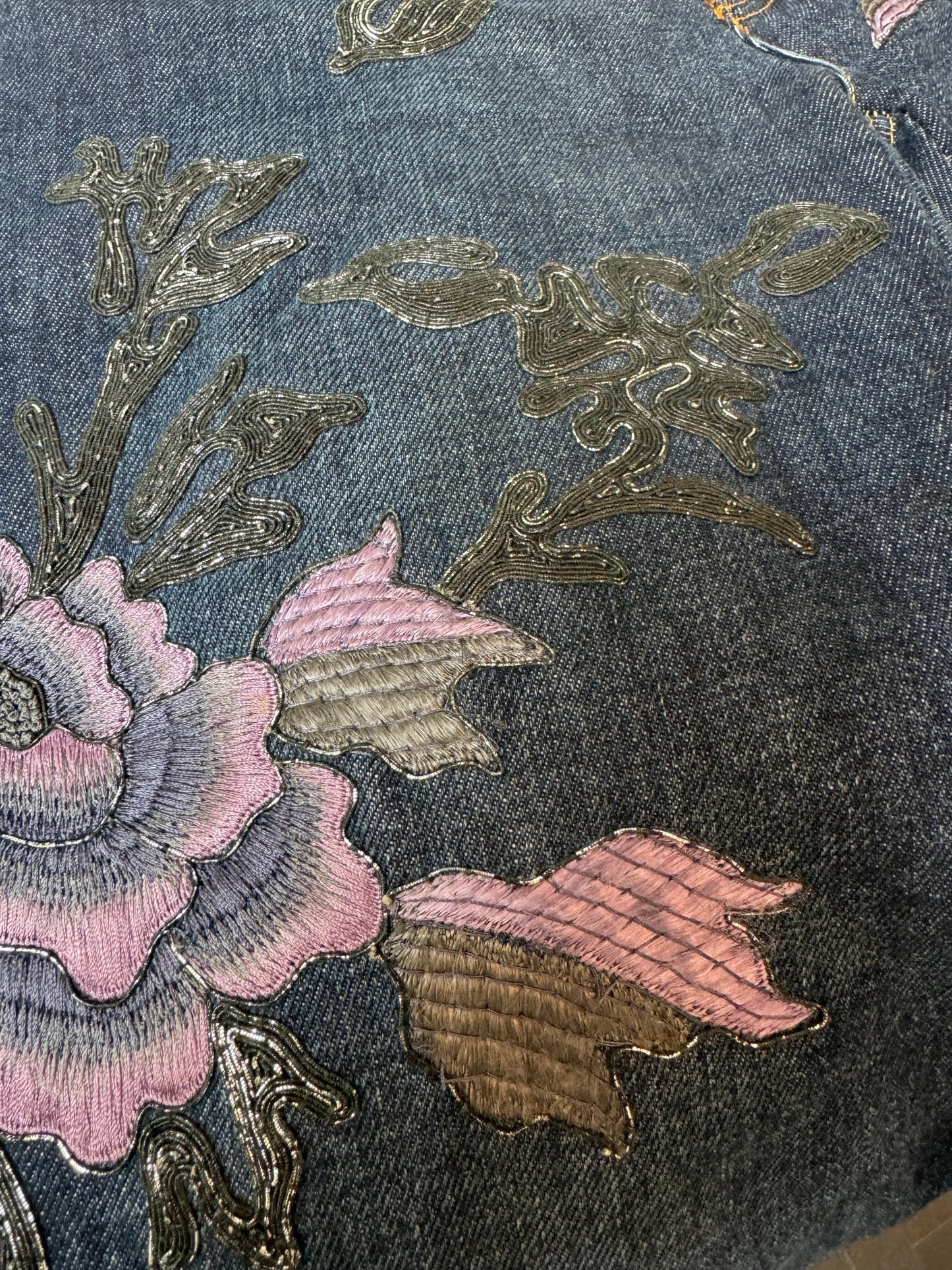 Jeans with metallic soutache embroidery with purple flowers.